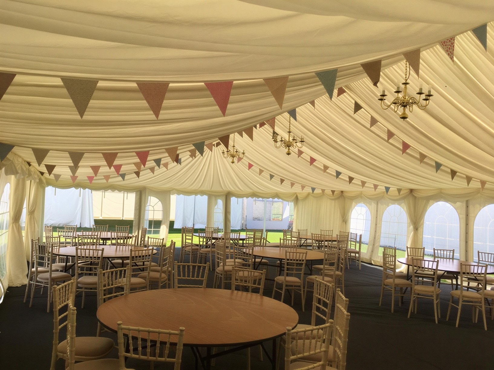 Marquee interior with bunting, chandeliers and dining tables